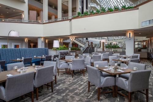 a restaurant with tables and chairs in a building at Crowne Plaza Hotel St. Louis Airport by IHG in Bridgeton