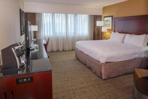 a hotel room with a bed and a television at Crowne Plaza Hotel St. Louis Airport by IHG in Bridgeton