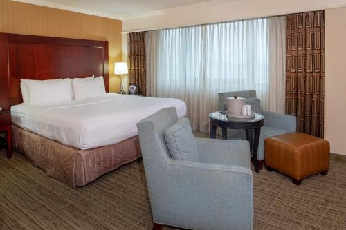 a hotel room with a bed and a chair at Crowne Plaza Hotel St. Louis Airport by IHG in Bridgeton