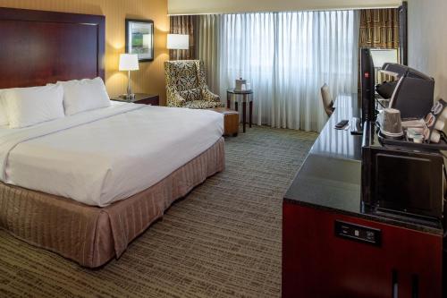 a hotel room with a bed and a television at Crowne Plaza Hotel St. Louis Airport by IHG in Bridgeton
