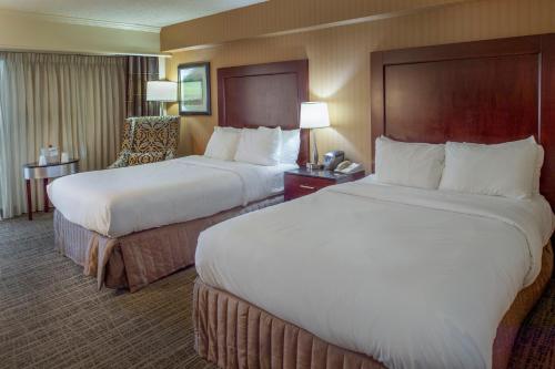 a hotel room with two beds and a chair at Crowne Plaza Hotel St. Louis Airport by IHG in Bridgeton