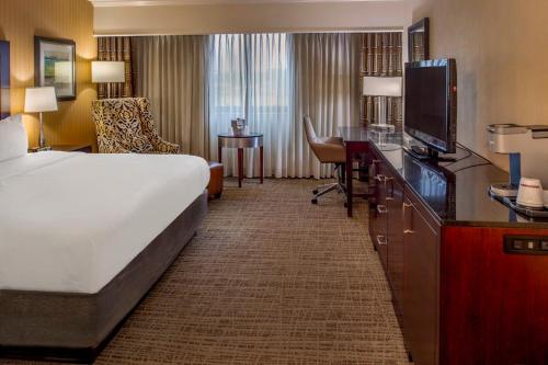 a hotel room with a bed and a flat screen tv at Crowne Plaza Hotel St. Louis Airport by IHG in Bridgeton