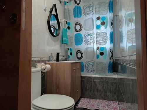 a bathroom with a toilet and a shower curtain at Casa Oasis Puertollano, una casa rural en Puertollano, agradable, con Piscina en zona tranquila in Puertollano