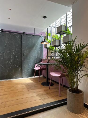 a dining room with a table and two pink chairs at Apto de lujo con jacuzzi in Santa Rosa de Cabal