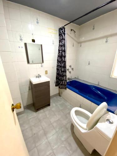 a bathroom with a toilet and a sink and a tub at RMS Hostal - Condesa in Mexico City