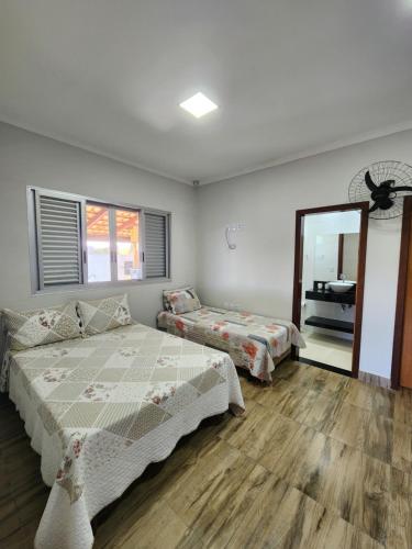 ein Schlafzimmer mit zwei Betten und einem Spiegel in der Unterkunft Rancho paraíso verde in Capitólio