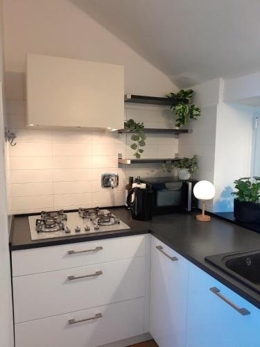 a kitchen with white cabinets and a stove top oven at Attico sul Mare By Smart-Home in Genova