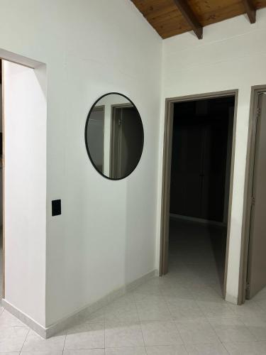a round mirror on a white wall with a hallway at Hermoso apartamento para disfrutar su estadía in Medellín