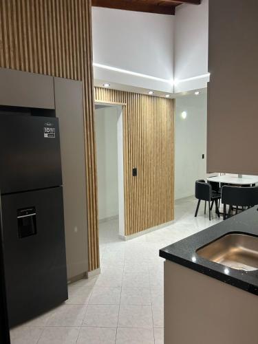 a kitchen with a black refrigerator and a table at Hermoso apartamento para disfrutar su estadía in Medellín