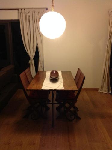 a dining room table with chairs and a light at Teavai in Faaa