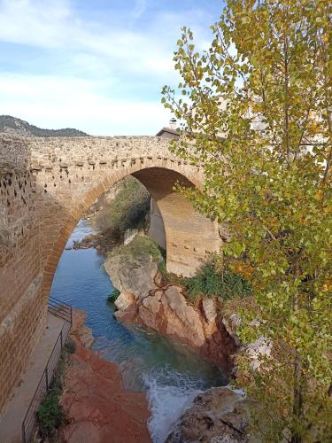 a stone bridge over a river with water underneath at Casa Carmeta Beceite in Beceite