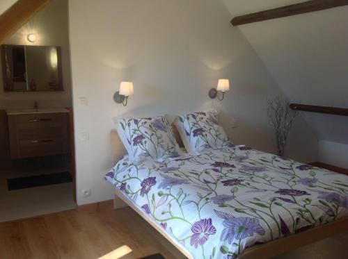 - une petite chambre dotée d'un lit avec un couvre-lit floral dans l'établissement L'annexe, à Saint-Étienne-la-Thillaye