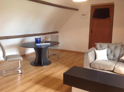 un salon avec un canapé et une table dans l'établissement L'annexe, à Saint-Étienne-la-Thillaye