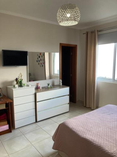 a bedroom with a bed and a dresser with a mirror at Casa da Piedade in Piedade