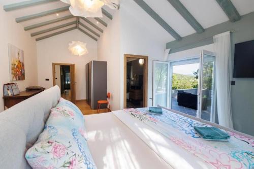 a bedroom with a large white bed with a large window at Villa Andrea in Zagvozd