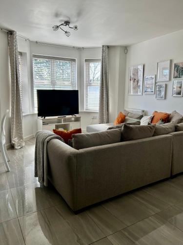 a living room with a couch and a flat screen tv at Modern 2 Bed Apartment With Free Parking And Netflix in Dawley
