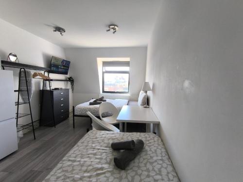 a room with a bed and a desk and a bedroom at Tooting Broadway Family Suite in London