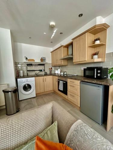 a living room with a couch and a kitchen at Modern 2 Bed Apartment With Free Parking And Netflix in Dawley