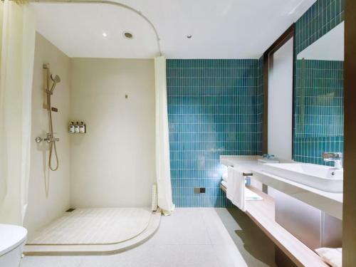 a bathroom with a tub and a sink and a toilet at Holiday Inn Express Hangzhou Jiangnan by IHG in Hangzhou
