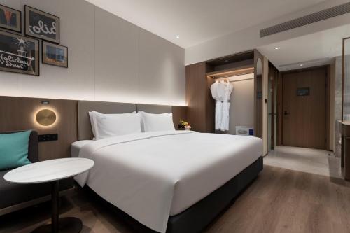a bedroom with a large white bed and a table at Holiday Inn Shanghai Jing'an in Shanghai