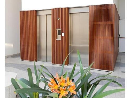 a plant in front of a row of elevators at Alojate en METRA Puerto Norte, luminoso estudio con pileta, gym y balcon in Rosario