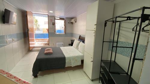 a small room with a bed and a bathroom at A Casa dos Mestres in Salvador