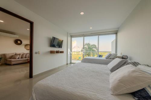 a white bedroom with two beds and a large window at Edificio Morros Vitri, 2 Bedrooms- Comfy Apartment in Cartagena de Indias