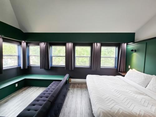 a green room with two beds and a couch at Copper Rose Retreat B&B in Invermere