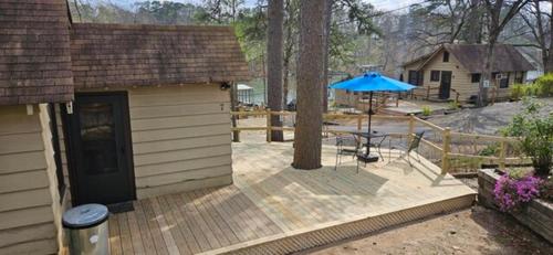 a patio with a table and a blue umbrella at #07 - Lakeview One Bedroom Cottage-Pet Friendly in Hot Springs