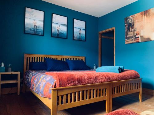 a bedroom with blue walls and a wooden bed at Stunning Beach house in Gorleston-on-Sea