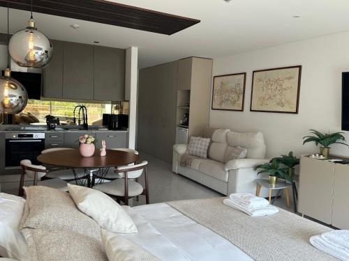 a kitchen and a living room with a couch and a table at Studio Luxury Quinta da Barca in Esposende
