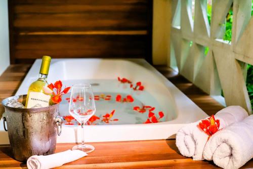 a bath tub with a bottle of wine and a glass at #2 Flat das Oliveiras Pipa Private Jacuzzi and AR in Pipa