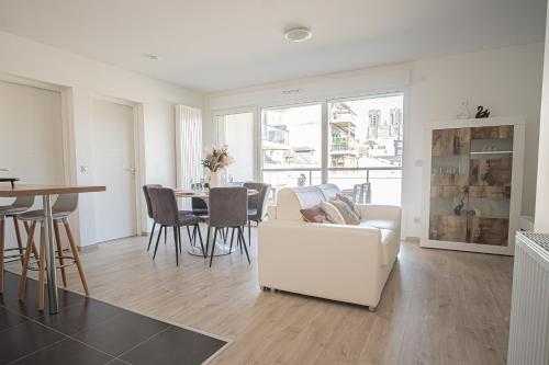 un salon avec un canapé blanc et une table dans l'établissement Prestige Apartment & Cathedral View, à Reims