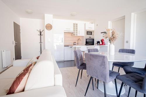 un salon blanc avec une table et des chaises blanches dans l'établissement Prestige Apartment & Cathedral View, à Reims
