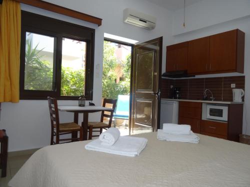 a room with a bed and a kitchen with a table at Lito Apartments Paleochora in Palaiochora