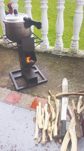 a grill sitting on the ground with wood on the ground at Quinta Divina Providencia in Fusagasuga