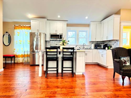 a kitchen with white cabinets and a kitchen island with bar stools at Delightful dwelling in Buffalo