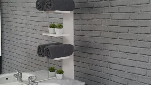La salle de bains est pourvue d'un lavabo blanc et d'un mur en briques. dans l'établissement Le Cocoon De Sacha, à Avize