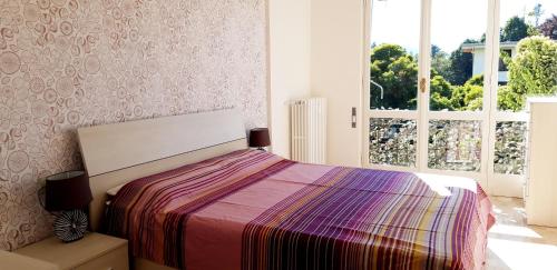 Un dormitorio con una cama con una manta colorida. en Cerro Lake view perfect for families, walk to the beach!, en Cerro Lago Maggiore