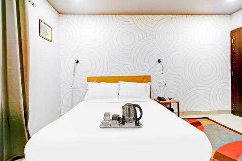 a bedroom with a white bed with a sewing machine on it at Townhouse Volga Homes in Guwahati