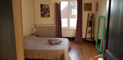 a small bedroom with a bed and a window at Au kouglof avec Netflix in Colmar
