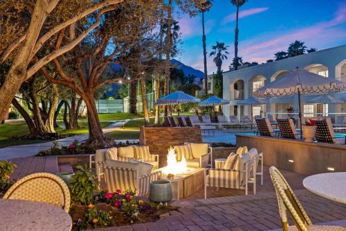 a patio with tables and chairs and a fire pit at Casa Palma Hotel & Bungalows in Palm Springs