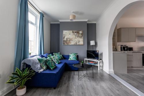 a living room with a blue couch and a table at Elm View Retreat in Durham