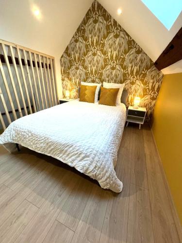 - une chambre avec un grand lit blanc et du papier peint dans l'établissement L'Authentique Centre &Gare, à Chalon-sur-Saône