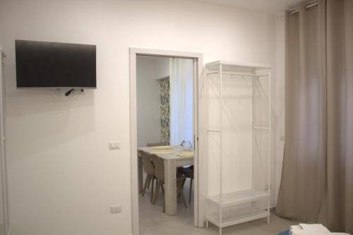 a room with a table and a television on a wall at RealeBorbonica-Intero Appartamento Con Ampio Terrazzino in Portici