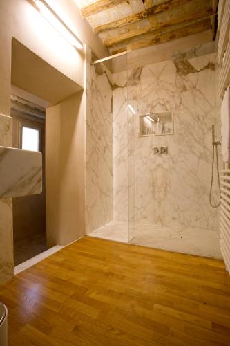 a bathroom with a shower with a glass door at Casa della Colonna, Luxury and comfort in the heart of Lucca in Lucca