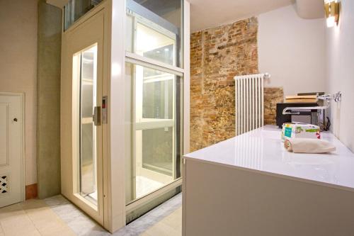 a kitchen with a white counter and a window at Casa della Colonna, Luxury and comfort in the heart of Lucca in Lucca