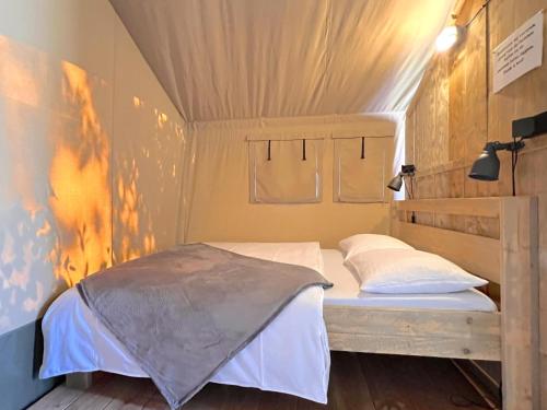 a small bedroom with a bed and a ladder at De Bij in Hulshorst
