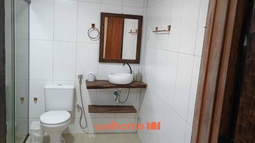 a bathroom with a toilet and a sink and a mirror at Chalé com vista em Lavras Novas , MG in Lavras Novas