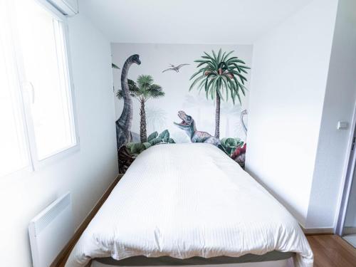 - une chambre avec un lit recouvert de palmiers et de dinosaures dans l'établissement Maison 2 Chambres avec Terrasse, 2 Parkings et Piscine, à Nîmes